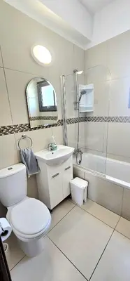 a white bathroom with a toilet and a sink at Agia Thekla bungalow with pool in Ayia Napa