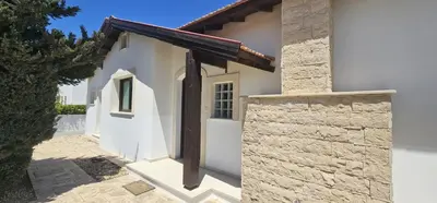 a white house with a gambrel roof at Agia Thekla bungalow with pool in Ayia Napa