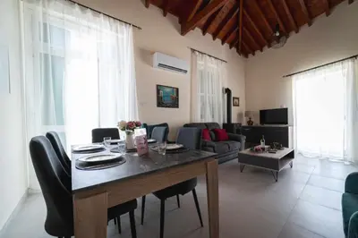 a living room with a table with chairs and a couch at Elite luxury Suites in Omodos