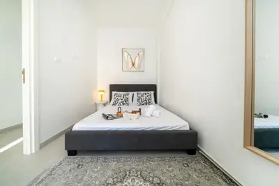 a bedroom with a bed and a mirror at Central 2 bedroom flat in Nicosia