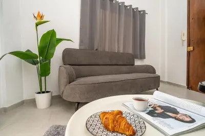 a coffee table with a plate of croissants and a chair at Central 2 bedroom flat in Nicosia