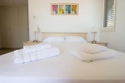 a white bed with two white towels on it at Frontline Sea-View Villa in Paralimni