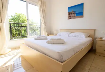 a bedroom with a large bed with two towels on it at Frontline Sea-View Villa in Paralimni