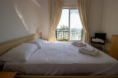 a bedroom with a white bed with towels on it at Frontline Sea-View Villa in Paralimni