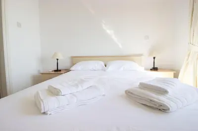 a white bed with two white towels on it at Frontline Sea-View Villa in Paralimni
