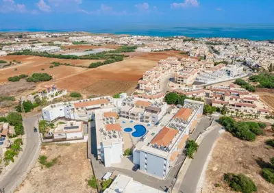 an aerial view of a city with white buildings and the ocean at Serenity Apartment with Pool in Paralimni