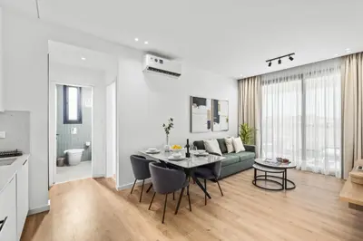 a white living room with a table and a couch at Artemis 304 - Seaside Stories in Livadhia