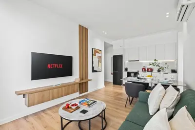 a living room with a couch and a tv on a wall at Artemis 304 - Seaside Stories in Livadhia
