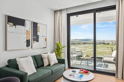 a living room with a green couch and a table at Artemis 304 - Seaside Stories in Livadhia