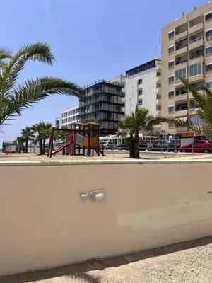 a view of a playground with palm trees and buildings at Sandy Nest Studio in Larnaka