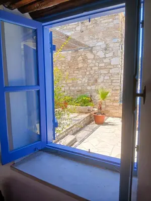 an open window with a view of a patio at Hillside Cozy Apartment in Skarinou
