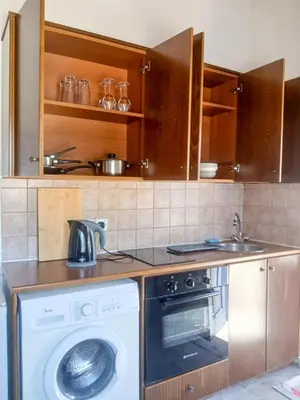 a kitchen with a washing machine and a sink at Hillside Cozy Apartment in Skarinou