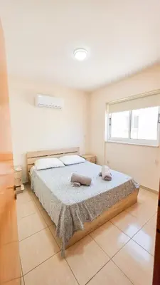 a bedroom with a bed with two towels on it at The Poolside Escape Apartment in Larnaka