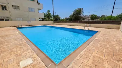 a swimming pool in front of a building at The Poolside Escape Apartment in Larnaka