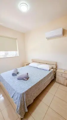 a bedroom with a bed with two towels on it at The Poolside Escape Apartment in Larnaka