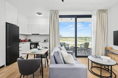 a kitchen and living room with a couch and a table at Artemis 103 - Seaside Stories in Livadhia