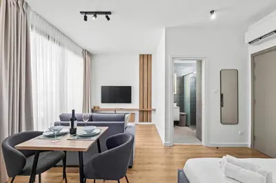 a living room with a table and chairs and a couch at Artemis 103 - Seaside Stories in Livadhia