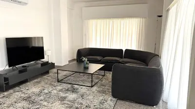 a living room with a couch and a television at Modern 3BDR_Top Floor_Lux_Suite_Balcony in Limassol