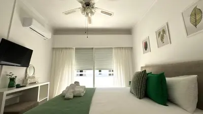 a bedroom with a bed with green and white pillows at Modern 3BDR_Top Floor_Lux_Suite_Balcony in Limassol
