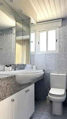 a bathroom with a sink and a toilet and a mirror at Modern 3BDR_Top Floor_Lux_Suite_Balcony in Limassol
