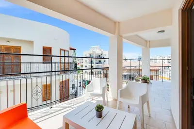 a balcony with white furniture and a view of the city at Market View Apartment - Near The Beach in Larnaka