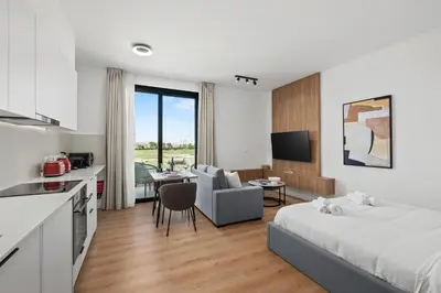 a bedroom with a bed and a kitchen and a living room at Artemis 205 - Seaside Stories in Livadhia
