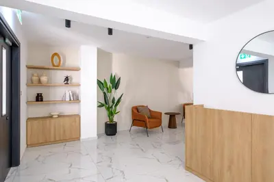 a living room with a chair and a mirror at Artemis 205 - Seaside Stories in Livadhia