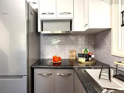 a kitchen with white cabinets and a black counter top at Elegant Beach Villa Moonstone II in Meneou