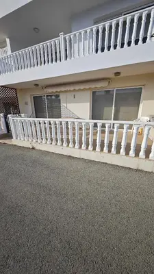 a house with a white railing and a balcony at Nissi 87 Apartment - Luxcyservices in Ayia Napa