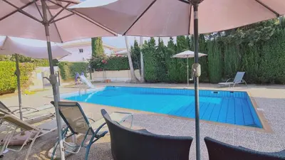 a swimming pool with umbrellas and chairs and a swimming pool at Nissi 87 Apartment - Luxcyservices in Ayia Napa