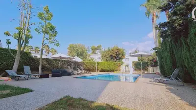 a swimming pool with lounge chairs and a swimming pool at Nissi 87 Apartment - Luxcyservices in Ayia Napa