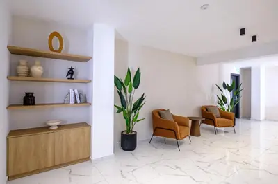 a lobby with chairs and a table and a plant at Artemis 105 - Seaside Stories in Livadhia