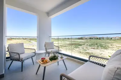 a living room with a couch and chairs and a large window at Artemis 105 - Seaside Stories in Livadhia