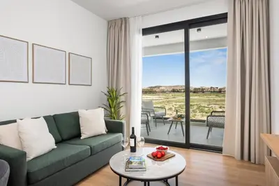 a living room with a green couch and a table at Artemis 105 - Seaside Stories in Livadhia