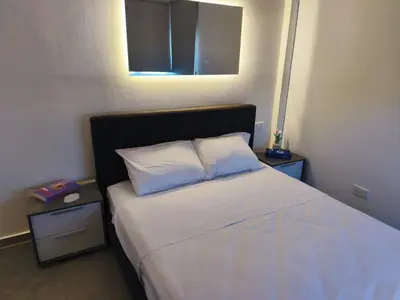 a bedroom with a bed with two pillows and two tables at Joyscape beachfront residence in Larnaka