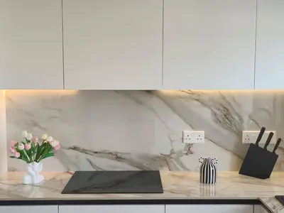 a kitchen with a counter with pink flowers in a vase at Joyscape beachfront residence in Larnaka