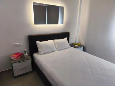 a bed with two pillows and a mirror on the wall at Joyscape beachfront residence in Larnaka