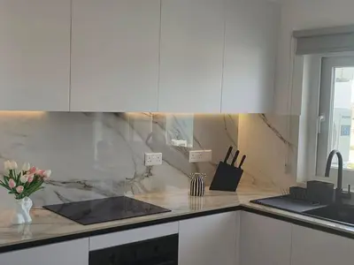 a kitchen with white cabinets and a counter top at Joyscape beachfront residence in Larnaka