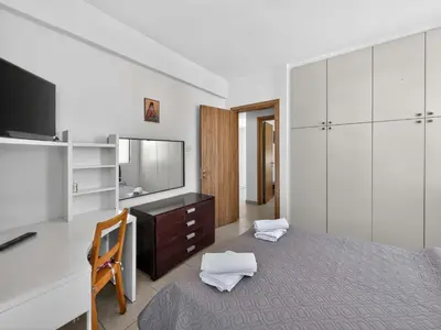a bedroom with a bed and a dresser and a television at Villa Rena - 3BR Retreat near Kalamies Beach in Paralimni