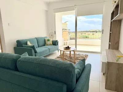 a living room with two blue couches and a table at Majestic Sea View Apartment in Tersephanou