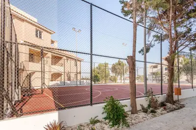 a tennis court behind a fence with a basketball court at Majestic Sea View Apartment in Tersephanou