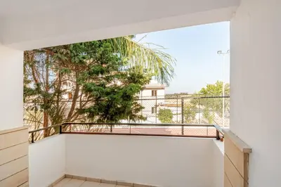 a balcony with a view of a palm tree at Majestic Sea View Apartment in Tersephanou