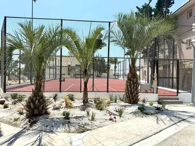 two palm trees in front of a tennis court at Majestic Sea View Apartment in Tersephanou