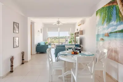 a dining room and living room with a white table and chairs at Majestic Sea View Apartment in Tersephanou