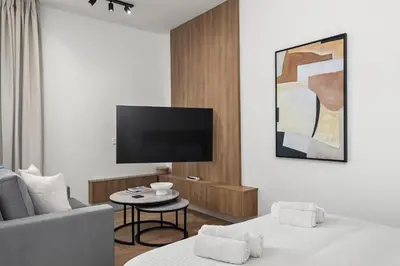 a living room with two beds and a flat screen tv at Artemis 106 - Seaside Stories in Livadhia