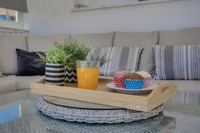a coffee table with a drink and bowls of food at Penthouse Central Larnaca The 'Veranda' Elena Court in Larnaka