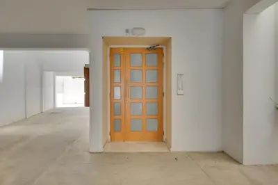 an empty hallway with a wooden door in a room at Penthouse Central Larnaca The 'Veranda' Elena Court in Larnaka