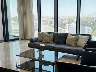 a living room with a couch and a glass table at SkyHigh Park View Residence in Nicosia