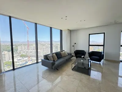 a living room with a couch and chairs in a building at SkyHigh Park View Residence in Nicosia