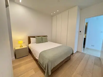a bedroom with a bed and a lamp on a night stand at SkyHigh Park View Residence in Nicosia